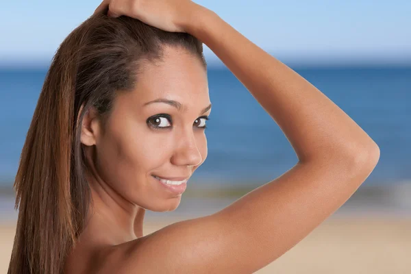 Hermosa mujer africana sosteniendo su cabello y sonriendo —  Fotos de Stock