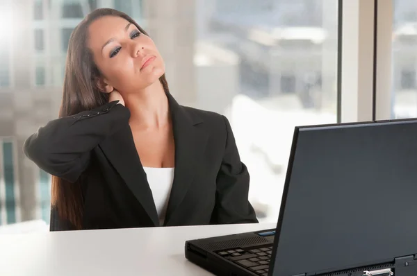 Empresária sentada em sua mesa cansada — Fotografia de Stock