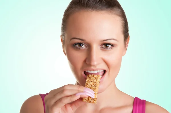 Mujer comiendo una barra de cereal — Foto de Stock