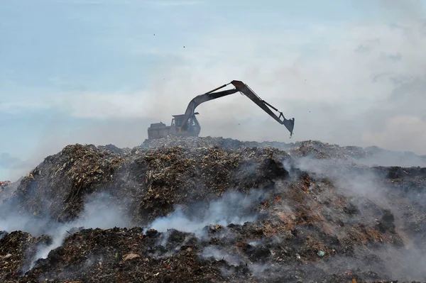 landfill excavator work on fire and smoke