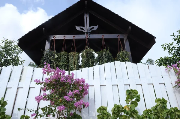 Cerca branca com flores e telhado gazebo — Fotografia de Stock