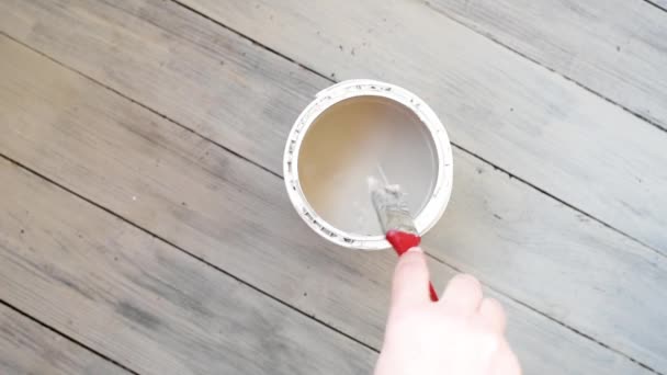 左撇子的女人用灰色的刷子刷地板 用左撇子手用浅色粉刷房间 — 图库视频影像