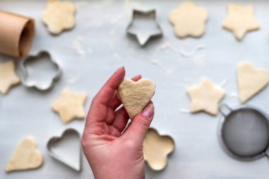 Kalp, yıldız, bulut ve çiçek şeklinde zencefilli kurabiye pişirmenin en güzel manzarası. Noel ve Yeni Yıl konsepti, kış köylüleri için şenlikli hazırlıklar.