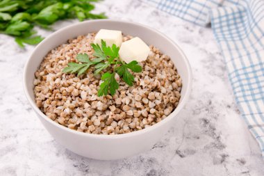 Gri arka planda bir tabakta taze pişmiş karabuğday lapası. Sağlıklı yiyecekler. Vejetaryen yemeği..