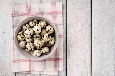 Bıldırcın yumurta bir kase ahşap arka plan üzerinde