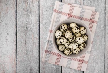 Bıldırcın yumurta bir kase ahşap arka plan üzerinde