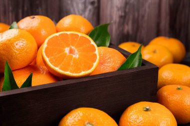 Taze mandalina portakalları ya da mandalina ve ahşap kutuda yapraklar. Nefis mandalinalar.
