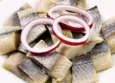 Terbiye edilmiş ringa balığı, dilimlenmiş balık filetosu ve doğranmış soğan halkaları.