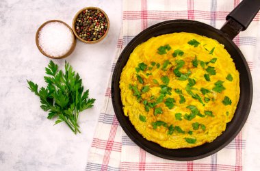 Gri arka plan manzaralı maydanozlu ev yapımı yumurta omleti.