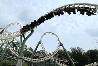 Hollanda 'daki bir lunaparkta gölün yanında iki hız treni.