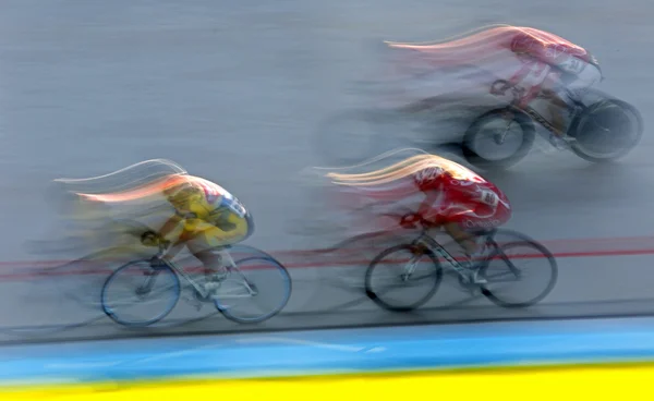 Tres ciclistas pista movimiento desenfoque rayas — Foto de Stock