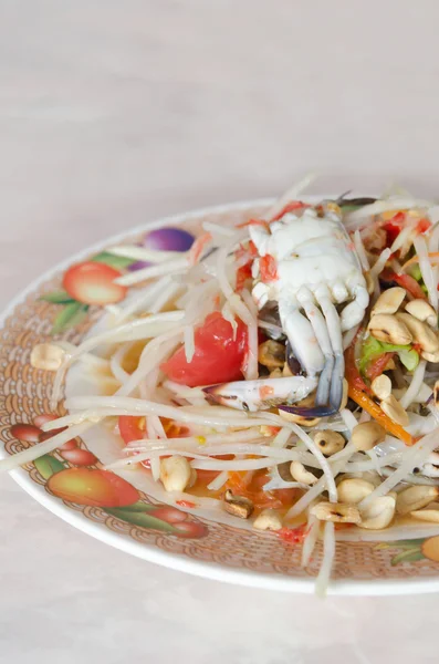 Пряный салат из папайи на блюде — стоковое фото
