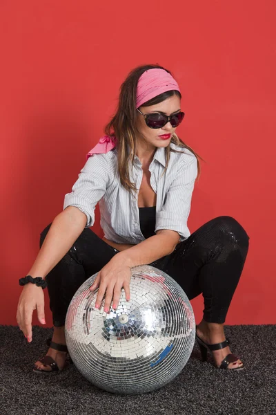Young Woman with disco ball Over red background — Stock Photo, Image