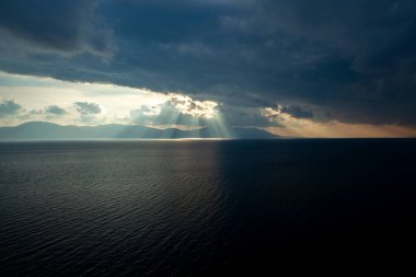 Fırtınadan önce gün batımında, güneş ışınları bulutları delip geçer.