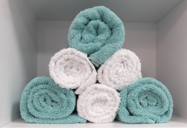 folded towels in the shelf, close up, white and blue