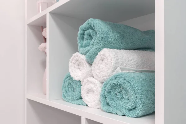 folded towels in the shelf, close up, white and blue