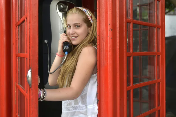 Unga flicka talar av typisk engelsk röd telefon — Stockfoto
