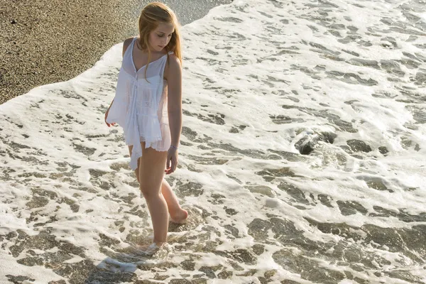 Mujer joven caminando en una playa de arena blanca —  Fotos de Stock