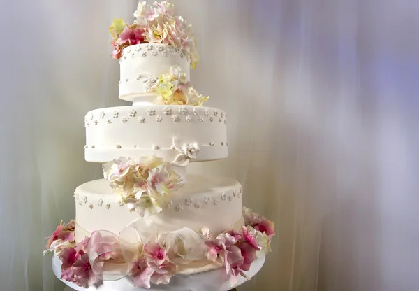 Big white wedding cake decorated with flowers