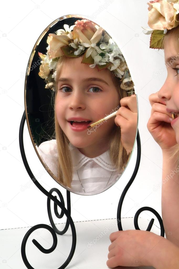 Adolable little girl looking in a mirror