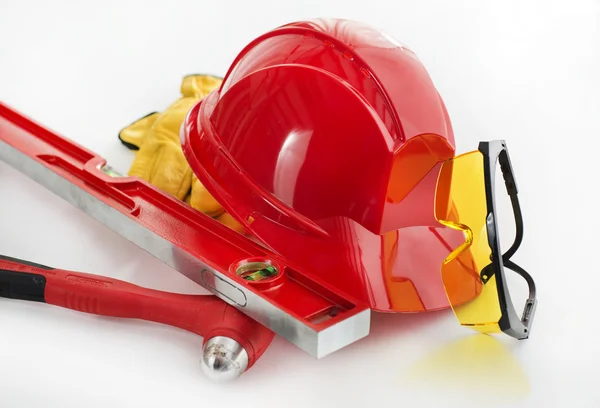 Red safety helmet with glasses, earphones and gloves — Stock Photo, Image