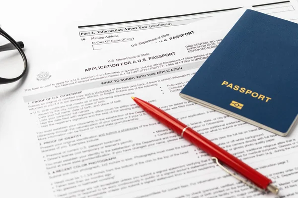 21 Eylül 2021, ABD. Yeni bir Amerikan pasaportu için başvuru formu, kırmızı kalem, beyaz arka planda gözlük. ABD belgesi. İş teması. Seçici odak.