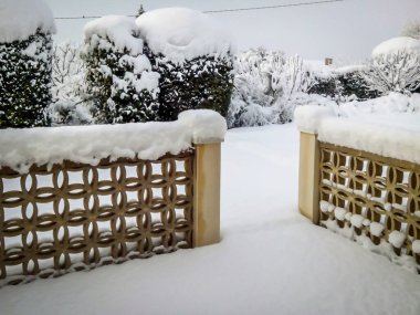 Güney Fransa 'da kalın bir karla kaplı bahçe ve duvarların manzarası