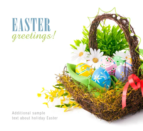 Huevos de Pascua en cesta con flores de primavera Fotos de stock