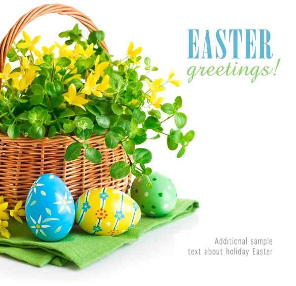 Easter eggs in basket with spring flowers — Stock Photo, Image