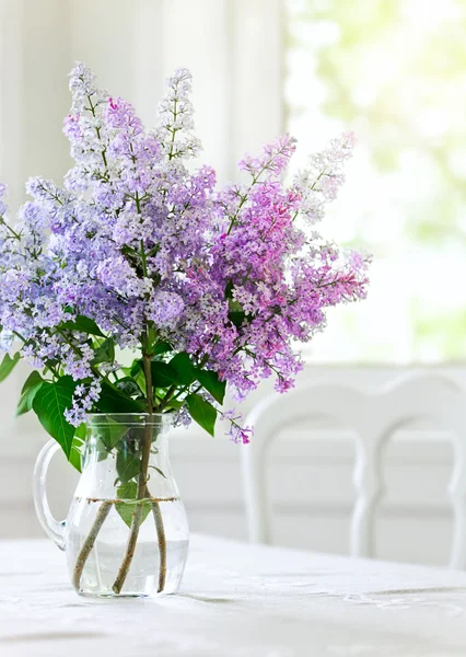 Δέσμη ιώδη λουλούδια στο βάζο στο τραπέζι — Φωτογραφία Αρχείου