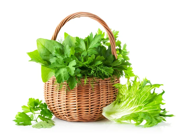 Green herbs in braided basket — Stock Photo, Image