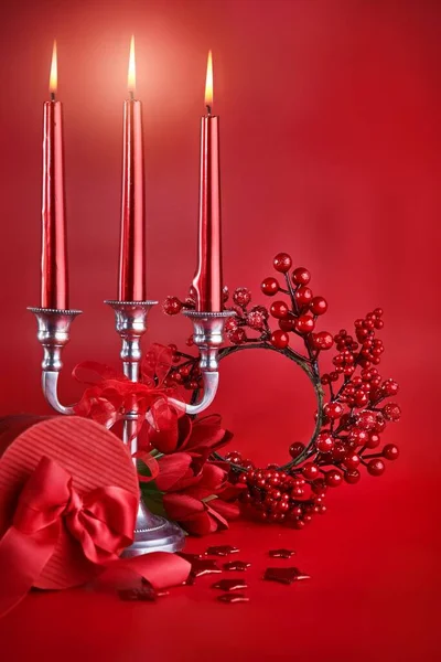 Decoração de Natal vermelho. Queimando velas castiçal, caixa de presente arco. — Fotografia de Stock