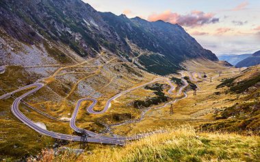 Panoramic mountain road Transfagarasan highway, the most beautiful road in Europe, Romania (Transfagarash) Ridge Fagaras. Scenic view at canyon in Carpathian mountains, Transylvania. Sunset sky clouds.