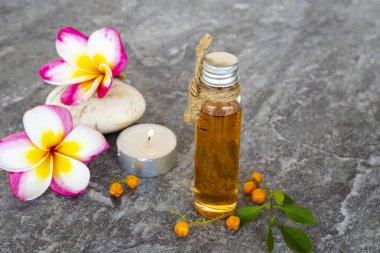 Doğal bitkisel yağlar çiçek özü frangipani kokusu aroma kokusu Asya düzenlemesinin yerel bitki örtüsü arka plandaki gri renkte yatıyordu