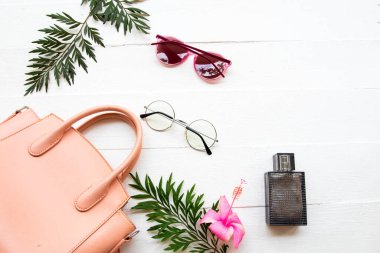 Pembe el çantası, parfüm ve güneş gözlüğü. Yaşam tarzı aksesuarları.