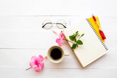 İş için defter planlayıcısı, sıcak kahve espresso ve çiçekler pembe amber düzenleme düz zemin üzerinde yatıyordu ahşap beyaz arka plan