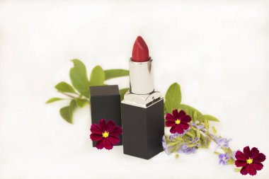 Ruj rengi kırmızı güzellik makyajı çiçek aranjmanlı yaşam tarzı düz arka planda beyaz renkte.