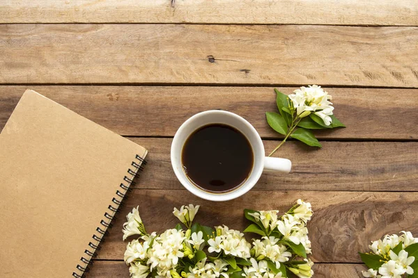 İş için dizüstü bilgisayar planlayıcısı, sıcak kahve, yasemin çiçekleri düzenleme düz arka plan ahşap üzerinde yatıyordu