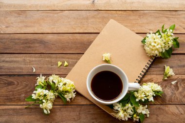 İş için dizüstü bilgisayar planlayıcısı, sıcak kahve, yasemin çiçekleri düzenleme düz arka plan ahşap üzerinde yatıyordu