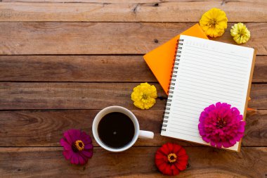 notebook planner for business work with hot coffee, flowers zinnia elegans arrangement flat lay style on background wooden