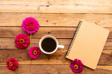 notebook planner for business work with hot coffee, flowers zinnia elegans arrangement flat lay style on background wooden