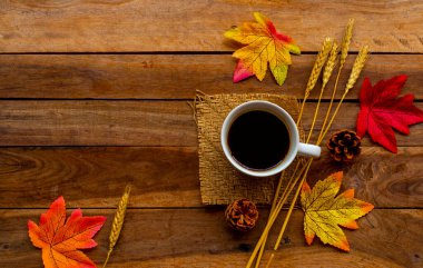 Sonbahar sezonunda yapraklı sıcak kahve espresso. Arka planda tahta üzerine kartpostal serili.