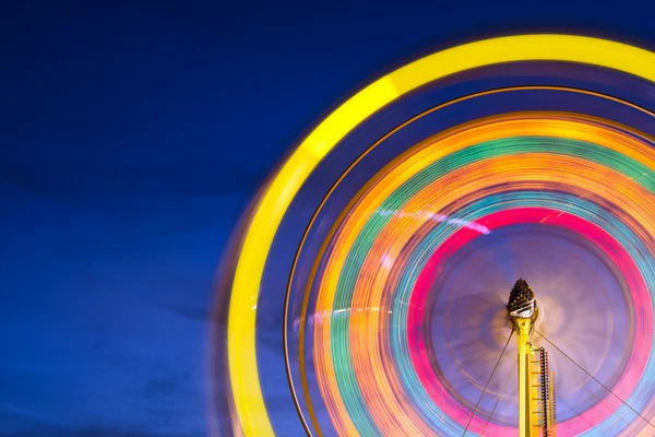 Roda gigante com movimento luzes embaçadas com espaço de cópia — Fotografia de Stock