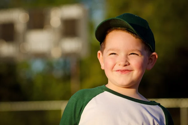 Retrato del jugador de béisbol infantil en el campo delante del marcador —  Fotos de Stock