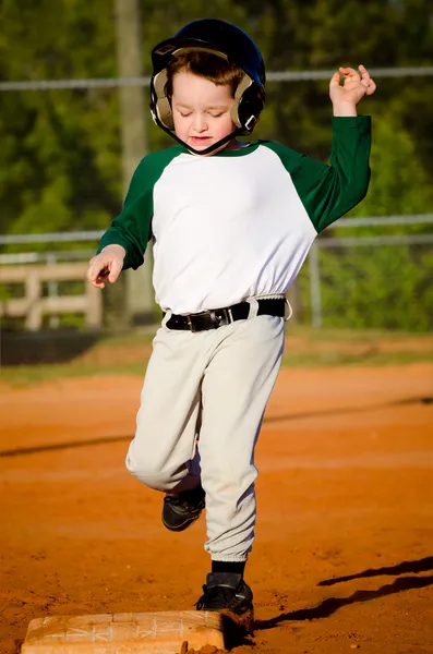 Jovem criança correndo bases enquanto joga beisebol — Fotografia de Stock