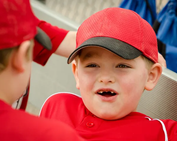 野球の試合の前にダッグアウトで幸せな子供の肖像画 — ストック写真