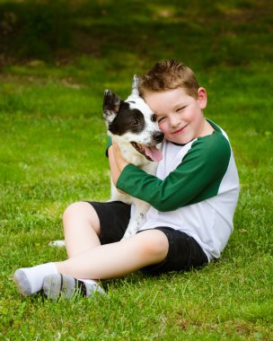 Çocuk sevgiyle onun evcil köpek, mavi SPLIT kucaklar