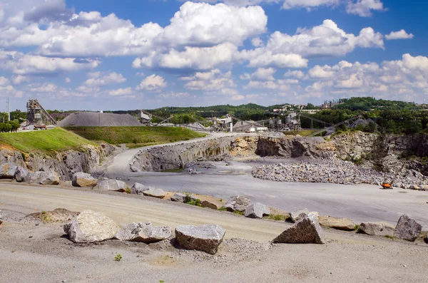 Working rock quarry under cloudy blue sky — Stock Photo, Image