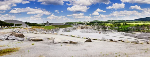 Working rock quarry under cloudy blue sky — Stock Photo, Image