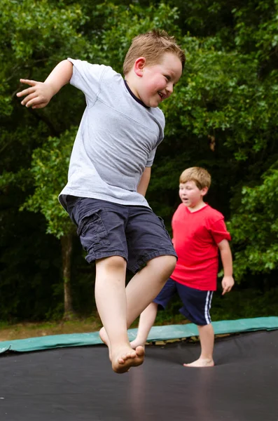 Bambino che gioca mentre salta sul trampolino all'aperto il giorno di primavera — Foto Stock